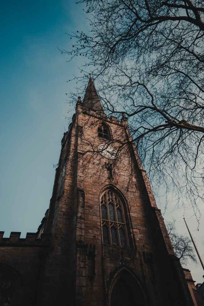 brown concrete building beside bare tree