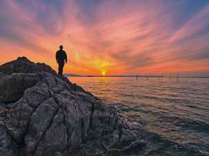 photo of person standing on rock formation